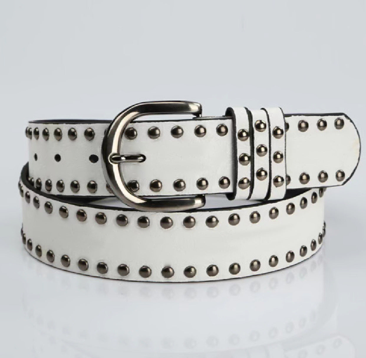 Cinturón de piel suave para mujer con hebilla y remaches decorativos.