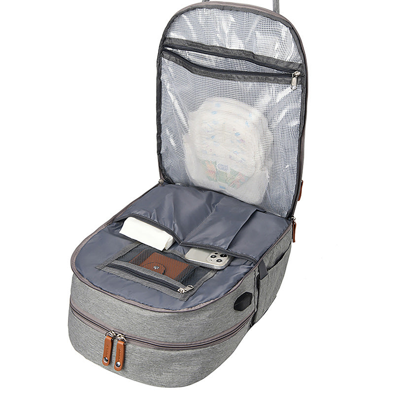 Bolsa multifuncional para cochecito con carga USB y compartimentos separados para ropa seca y húmeda.